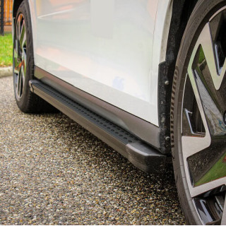 Festes Seitentrittbrett mit Aluminiumbeschichtung und schwarzer Kunststoffbeschichtung auf der Oberseite.